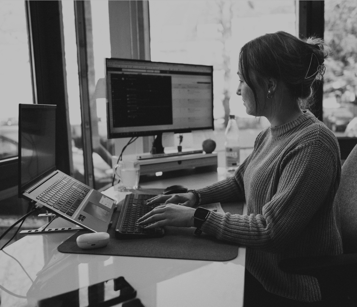 Junge Frau sitzt im modernen Büro und arbeitet konzentriert