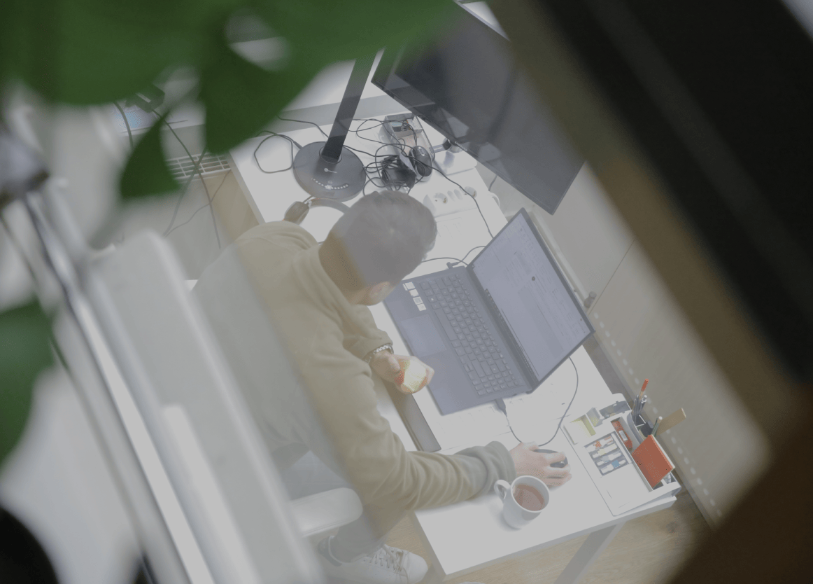 Person arbeitet an einem Laptop am Schreibtisch