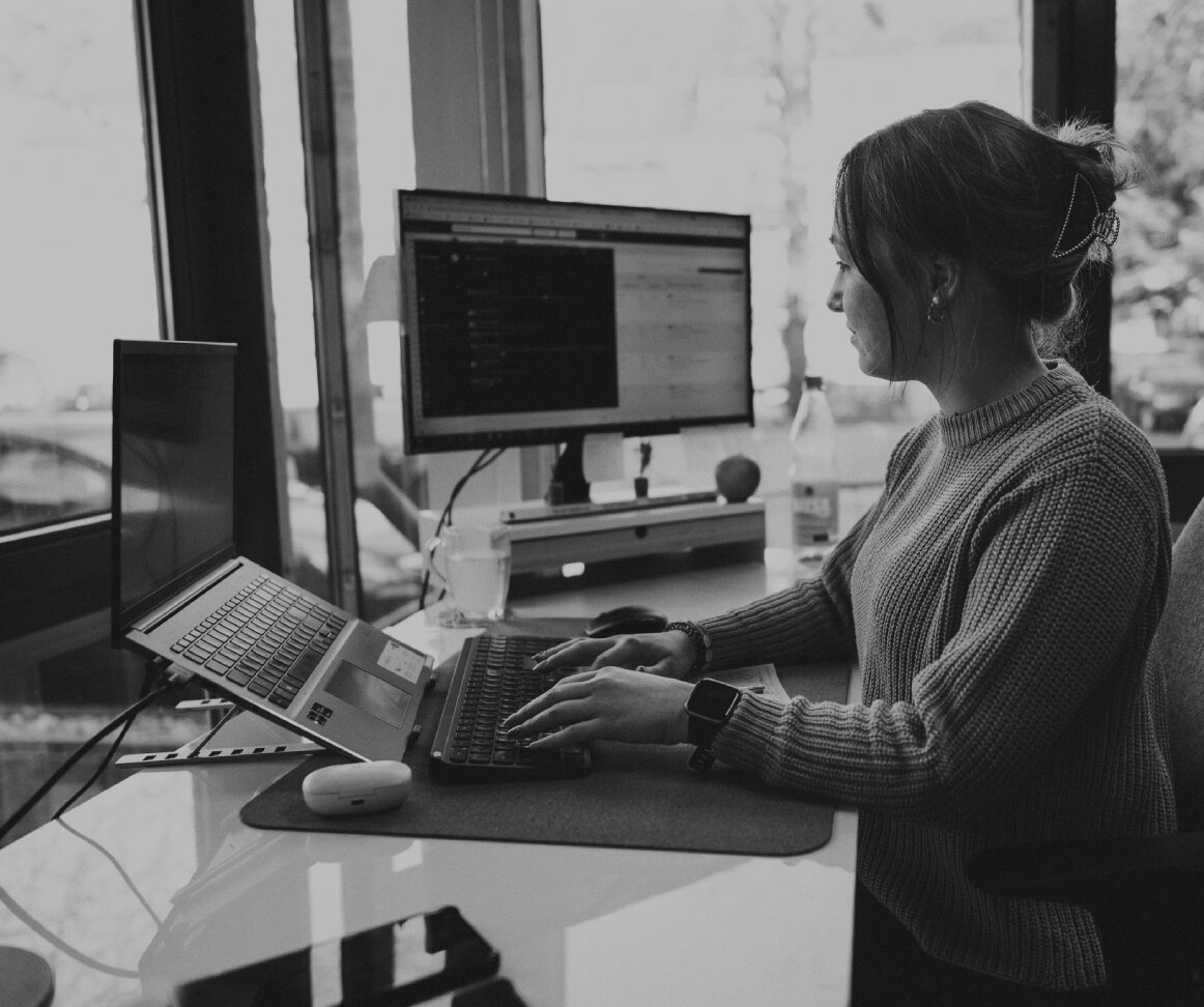 Junge Frau arbeitet konzentriert am Schreibtisch im modernen Büro